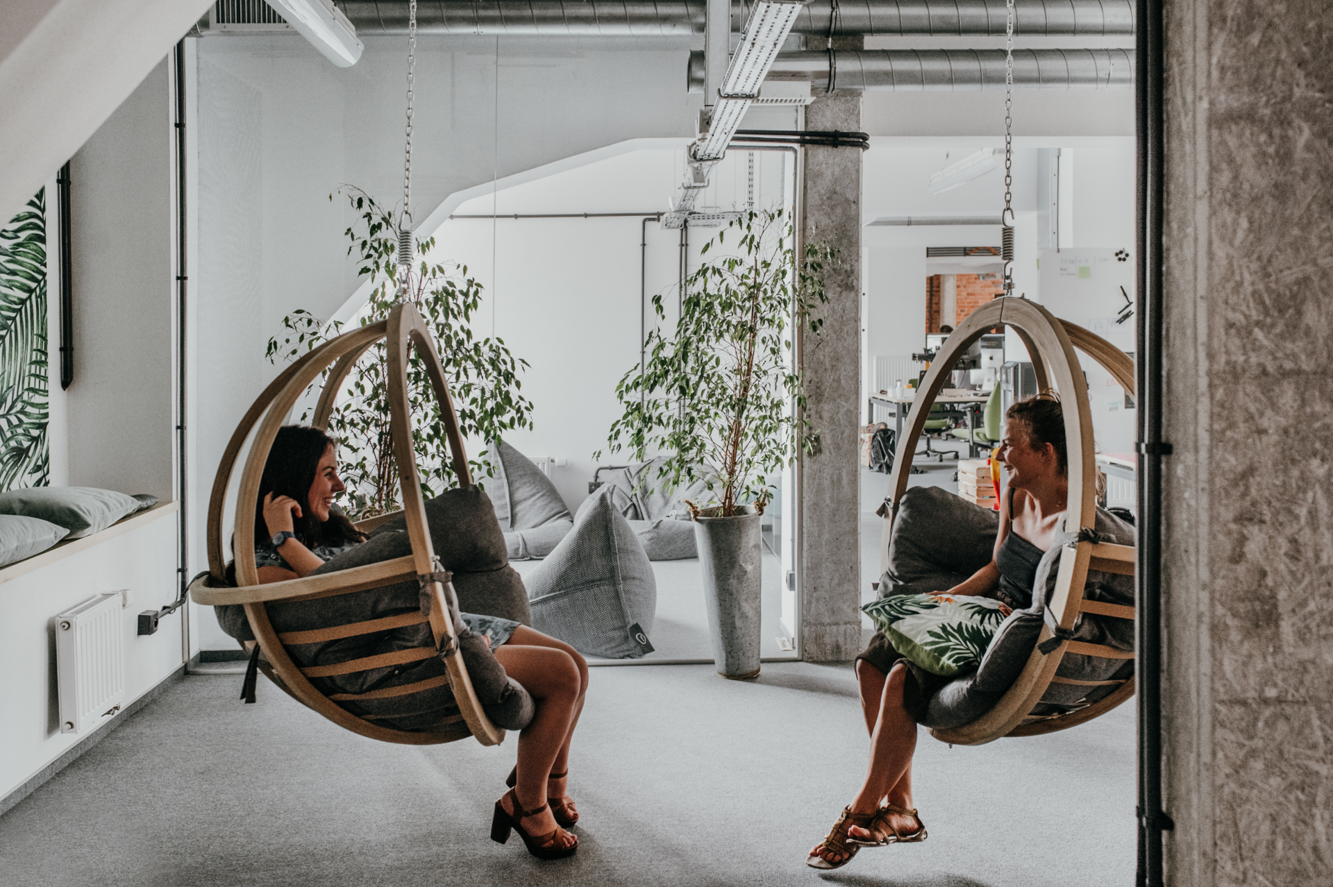 Two girls sitting on wooden wooden swings